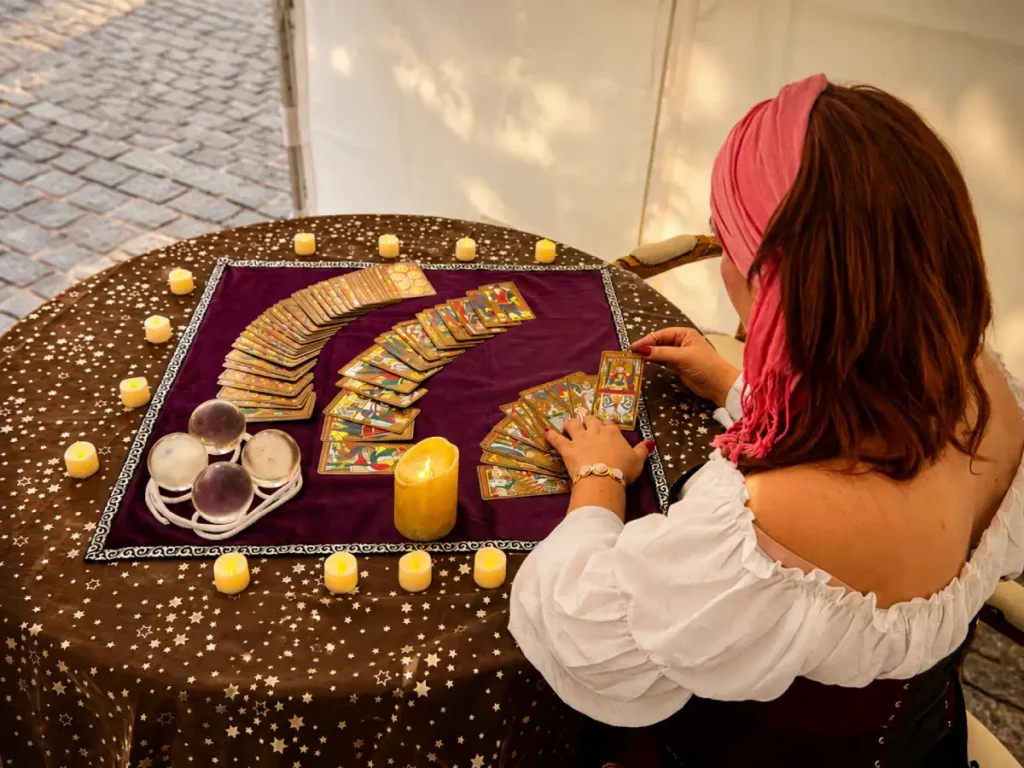 Mesa de tarot para eventos con cartas, velas y ambientación elegante