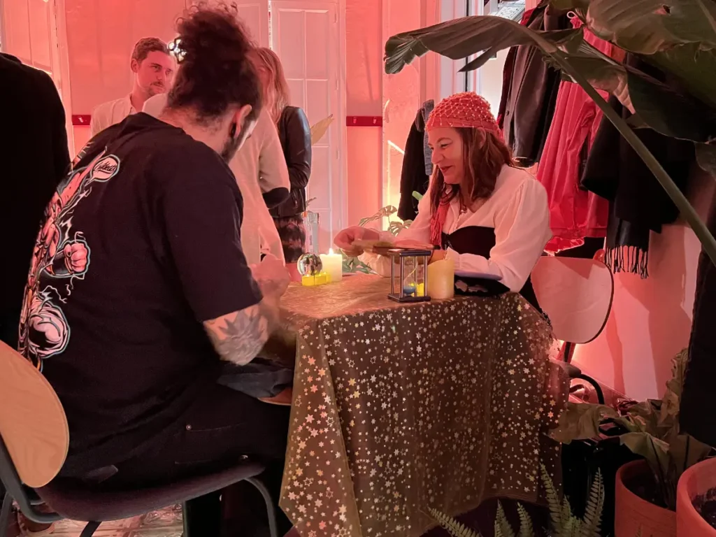 Ángela realizando una lectura de tarot a un invitado en un pub